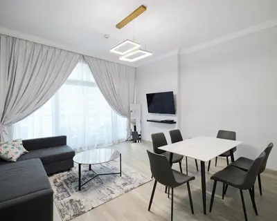 a living room with a couch and a table and chairs at 1 bedroom in Torch Tower Dubai Marina in Dubai