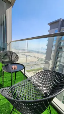 a metal chair and a table on a balcony at STAY BY LATINEM Luxury 1BR Holiday Home CVR A3002 near Burj Khalifa in Dubai