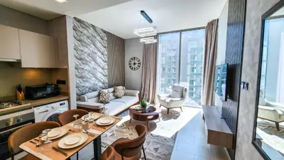 a kitchen and living room with a table and chairs at STAY BY LATINEM Luxury 1BR Holiday Home CVR A3002 near Burj Khalifa in Dubai