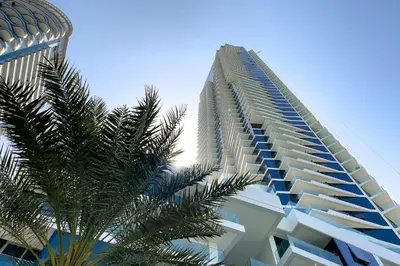 a tall building with a palm tree in front of it at Luxury Residence Stella Maris in Dubai
