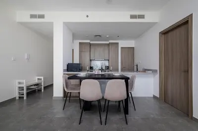 a dining room with a table and chairs and a kitchen at Luxury Residence Stella Maris in Dubai