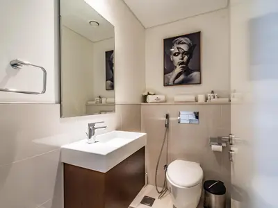 a bathroom with a sink and a toilet and a mirror at Charming 2Br in Boulevard Crescent - Downtown Dubai in Dubai