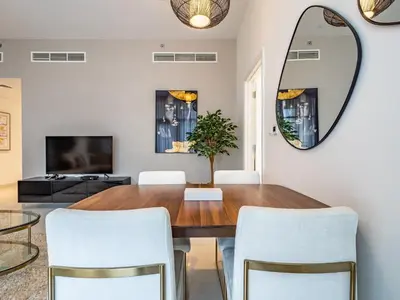 a dining room with a table and chairs and a mirror at Charming 2Br in Boulevard Crescent - Downtown Dubai in Dubai