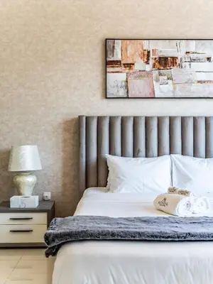 a bedroom with a bed and a picture on the wall at Charming 2Br in Boulevard Crescent - Downtown Dubai in Dubai