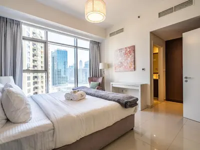 a bedroom with a large bed with a large window at Charming 2Br in Boulevard Crescent - Downtown Dubai in Dubai