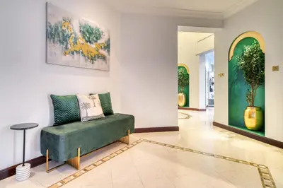 a living room with a green couch and a painting on the wall at Frond E Villa, Palm Jumeirah - Mint Stay in Dubai