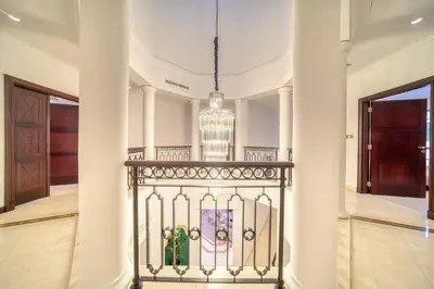 a hallway with a wrought iron fence and a chandelier at Frond E Villa, Palm Jumeirah - Mint Stay in Dubai