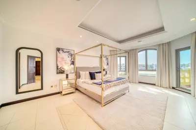 a bedroom with a canopy bed and a large window at Frond E Villa, Palm Jumeirah - Mint Stay in Dubai