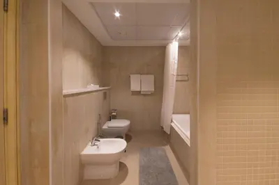 a bathroom with a toilet and a sink and a tub at Al Bateen Residences, Jumeirah Beach Residence - Mint Stay in Dubai