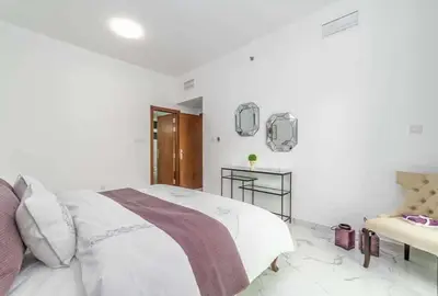 a white bedroom with a bed and a couch at Sea View Apartments Marina with Party Hall in Dubai