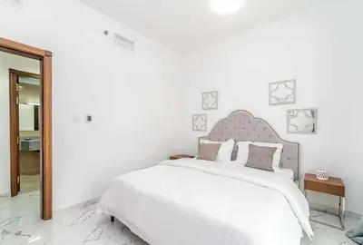 a white bedroom with a large bed and a mirror at Sea View Apartments Marina with Party Hall in Dubai
