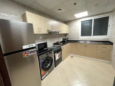 a kitchen with a refrigerator and a washing machine at Sea View Apartments Marina with Party Hall in Dubai
