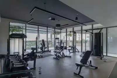 a gym with a lot of exercise equipment and windows at Vogue Emaar Beachfront Beach Vista near JBR and Palm Jumeirah, One Bedroom Apartment with Balcony and Private Beach, Access to all Amenities in Dubai