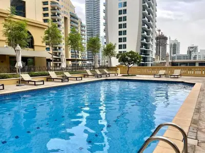 a large swimming pool with chairs and buildings at JBR Sea View 2 Bedroom Apartment in Dubai