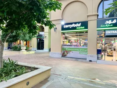 a store front of a shopping mall with a tree in front at JBR Sea View 2 Bedroom Apartment in Dubai