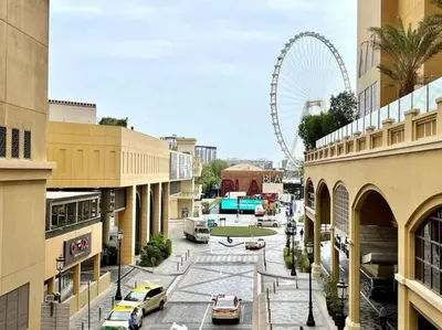 a city street with a ferris wheel in the background at JBR Sea View 2 Bedroom Apartment in Dubai
