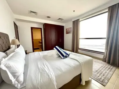 a bedroom with a white bed and a large window at JBR Sea View 2 Bedroom Apartment in Dubai