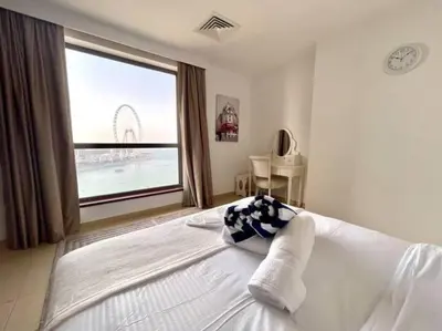 a bedroom with a large bed with a large window at JBR Sea View 2 Bedroom Apartment in Dubai