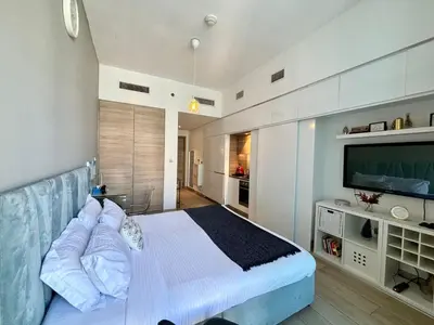 a bedroom with a bed and a flat screen tv at Beautiful Studio Apartment in Dubai Marina in Dubai