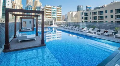 a swimming pool with chairs and a gazebo at Beautiful Studio Apartment in Dubai Marina in Dubai