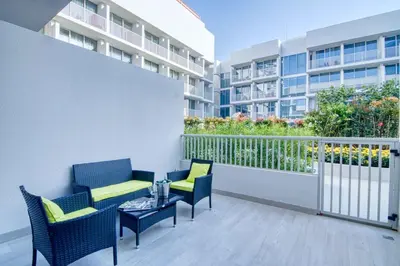 a balcony with chairs and a table on a building at The Smart Concierge - Luma 21 in Dubai
