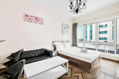 a living room with a couch and a table at StoneTree - Marina Diamond Studio - Near Metro Station in Dubai