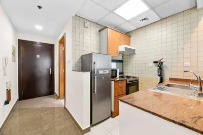 a kitchen with a stainless steel refrigerator and a sink at StoneTree - Marina Diamond Studio - Near Metro Station in Dubai