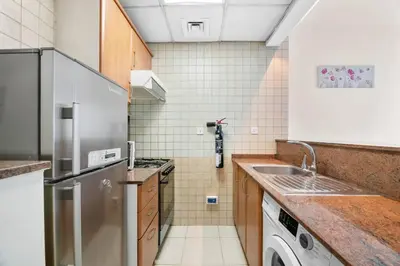 a kitchen with a stainless steel refrigerator and a dishwasher at StoneTree - Marina Diamond Studio - Near Metro Station in Dubai