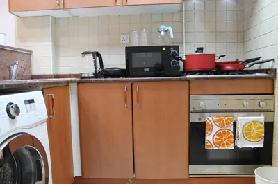 a kitchen with a stove and a washing machine at Newly furnished cozy 1 bedroom apartment close to JBR beach and metro in Dubai