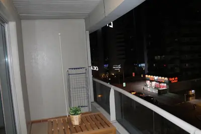 a balcony with a bench and a view of a city at night at Newly furnished cozy 1 bedroom apartment close to JBR beach and metro in Dubai