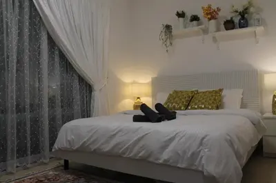 a bedroom with a large white bed with a window at Newly furnished cozy 1 bedroom apartment close to JBR beach and metro in Dubai