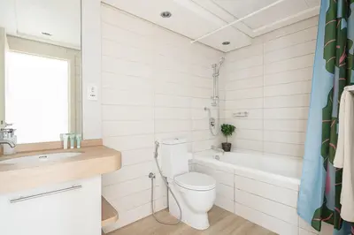 a bathroom with a toilet and a tub and a sink at Frank Porter - Burj Views Tower A in Dubai