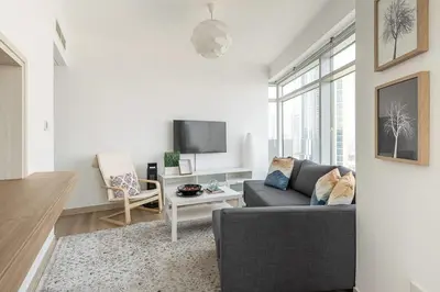 a living room with a couch and a tv at Frank Porter - Burj Views Tower A in Dubai