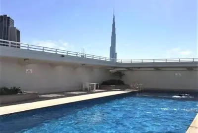 a large swimming pool with a bridge over it at Chic 3 bedroom apartment in Dubai