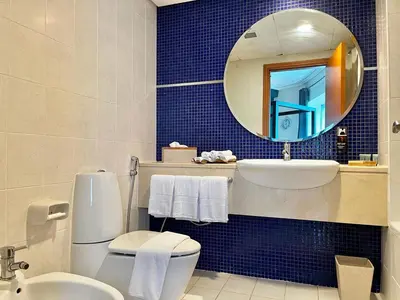 a bathroom with a toilet and a sink and a mirror at Chic 3 bedroom apartment in Dubai