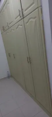 a row of white cabinets in a kitchen at Budget Place in Dubai