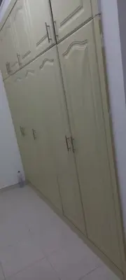a group of white cabinets in a kitchen at Budget Place in Dubai