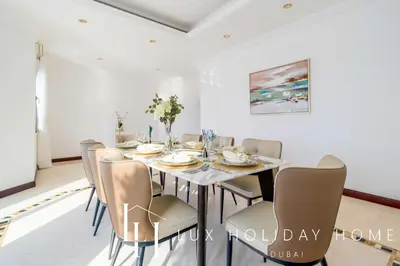 a dining room with a table and chairs at LUX The Ultimate Island Palm Villa in Dubai
