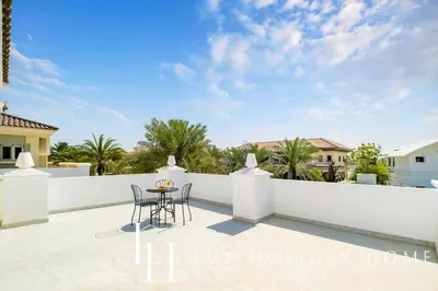 a view of the terrace of a house with a table and chairs at LUX The Ultimate Island Palm Villa in Dubai