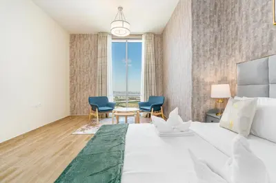 a bedroom with a large white bed and blue chairs at Lux BnB I Amna Tower I Panaromic Views in Dubai