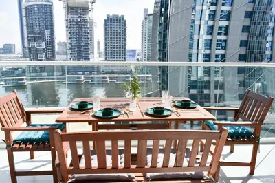 a wooden table and chairs on a balcony at Vera Residence with Canal View in Dubai