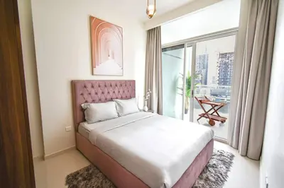 a bedroom with a bed and a large window at Vera Residence with Canal View in Dubai