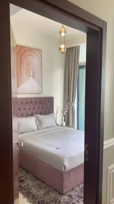 a bedroom with a bed with a pink headboard at Vera Residence with Canal View in Dubai
