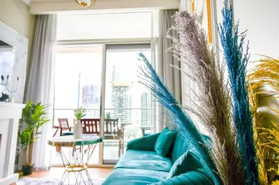 a blue couch in a living room with a large window at Vera Residence with Canal View in Dubai