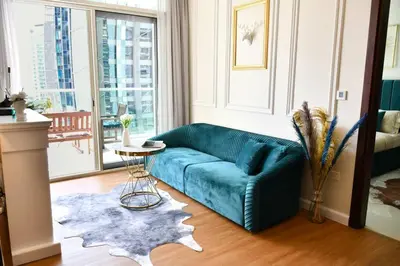 a living room with a blue couch and a table at Vera Residence with Canal View in Dubai