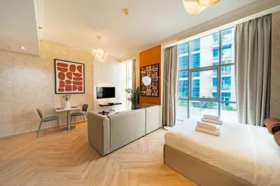 a bedroom with a large bed and a living room at Scala Tower Central Chic with a twist studio in Dubai