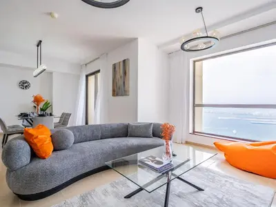a living room with a couch and a glass table at Spacious 2BR - Dubai Eye & Sea View - JBR in Dubai