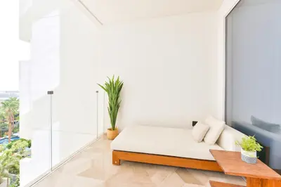 a white room with a bed and a table at Maison Privee - Glamourous Apt with Sea Views at FIVE Palm in Dubai