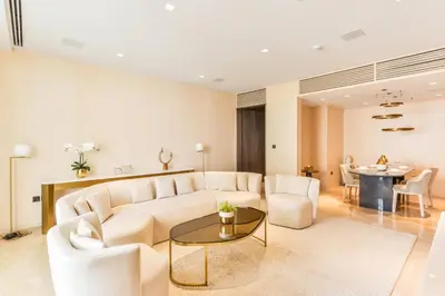 a living room with a white couch and a table at Maison Privee - Glamourous Apt with Sea Views at FIVE Palm in Dubai