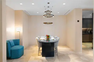 a dining room with a table and a blue chair at Maison Privee - Glamourous Apt with Sea Views at FIVE Palm in Dubai
